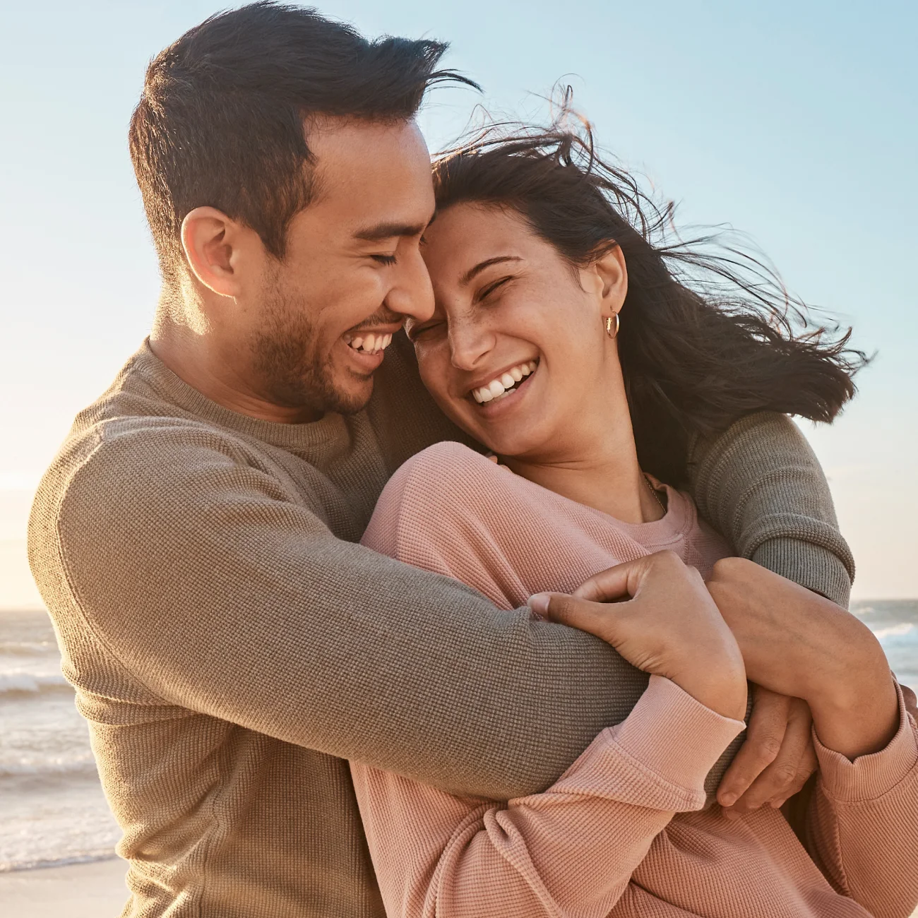 Young diverse biracial couple having fun at the beach together