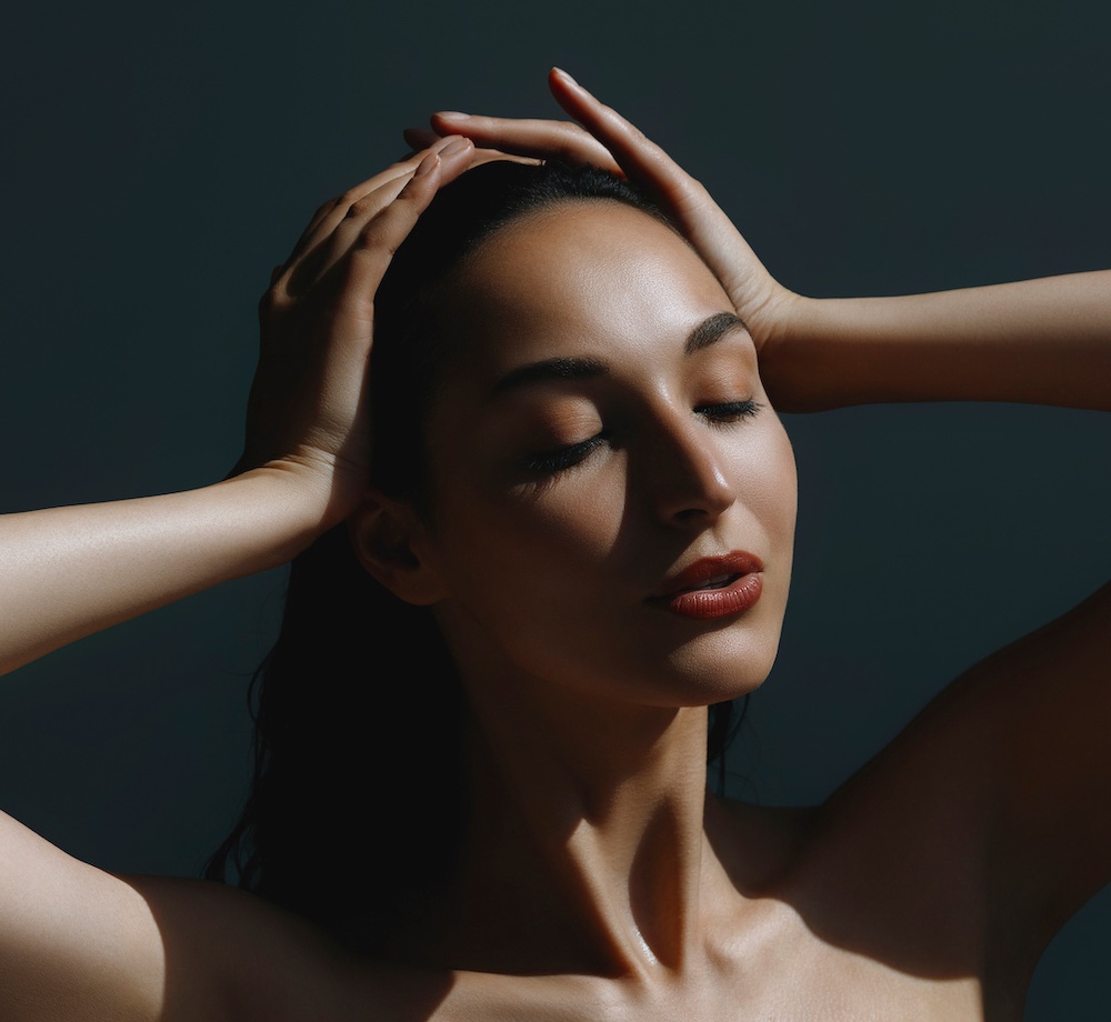 beautiful young woman with her hands on her head