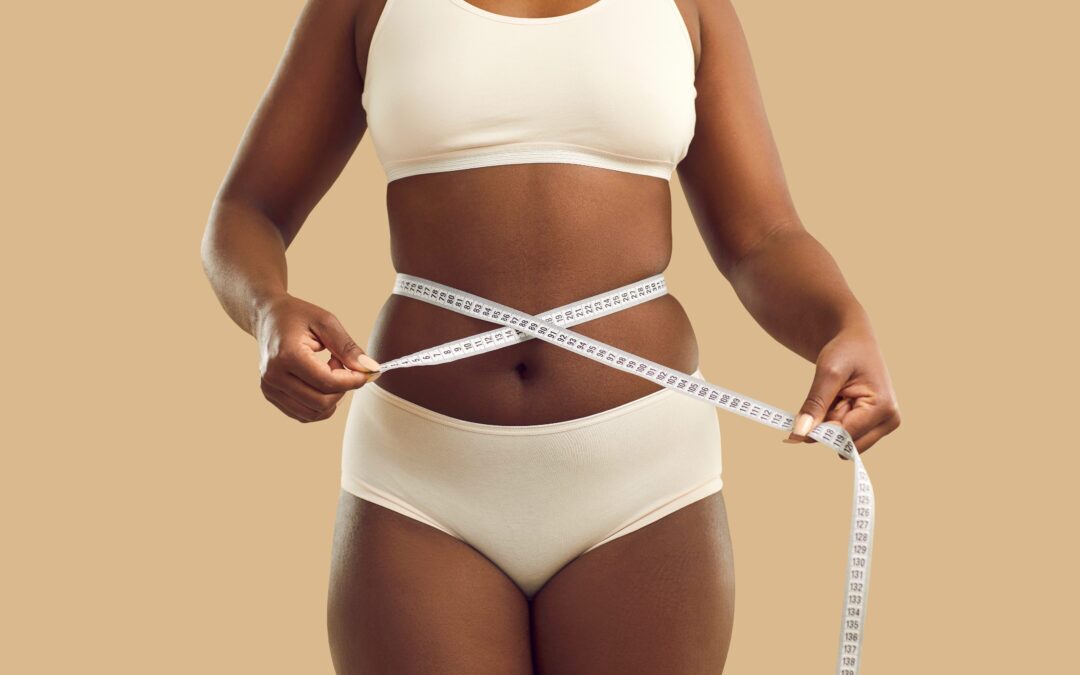 Black woman in underwear measure waist with tape