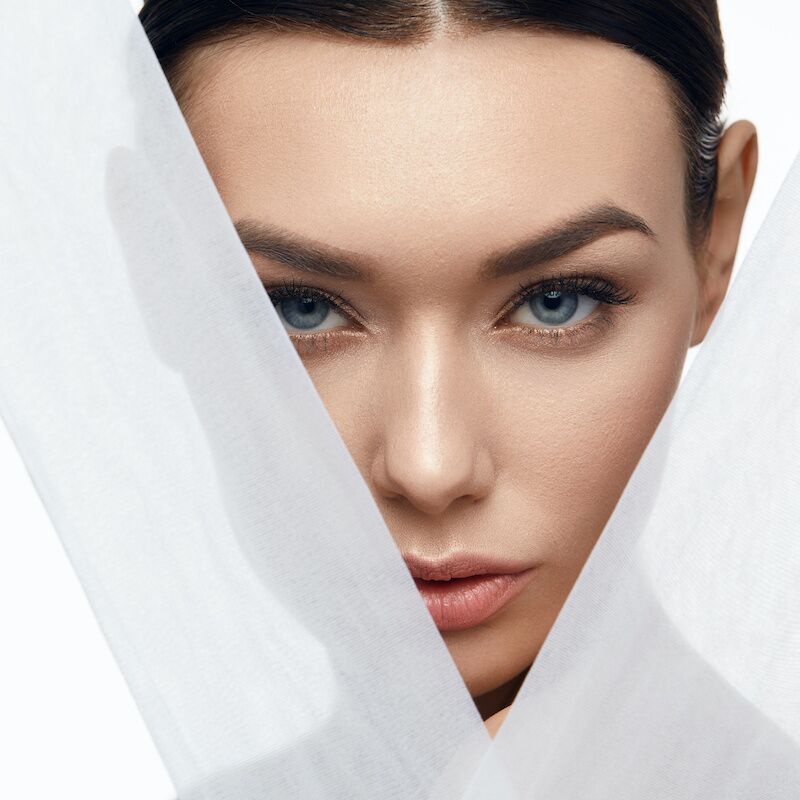 woman standing behind linen cloth