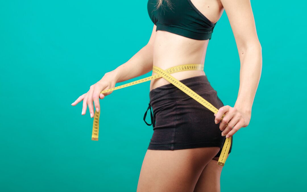 Fitness girl measuring her waistline